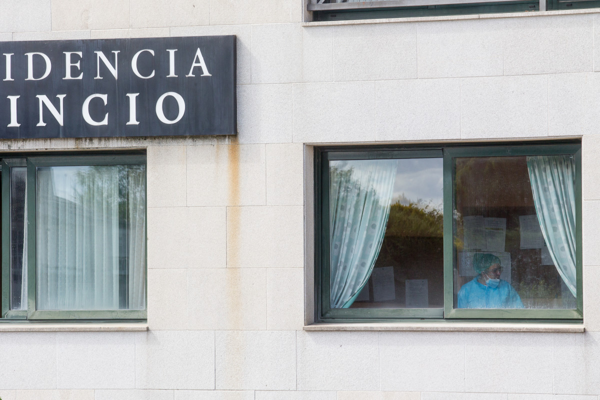 Unha sanitaria nunha xanela da residencia de anciáns do Incio, en Lugo (España), onde se detectou un brote de coronavirus, o 20 de agosto de 2020.