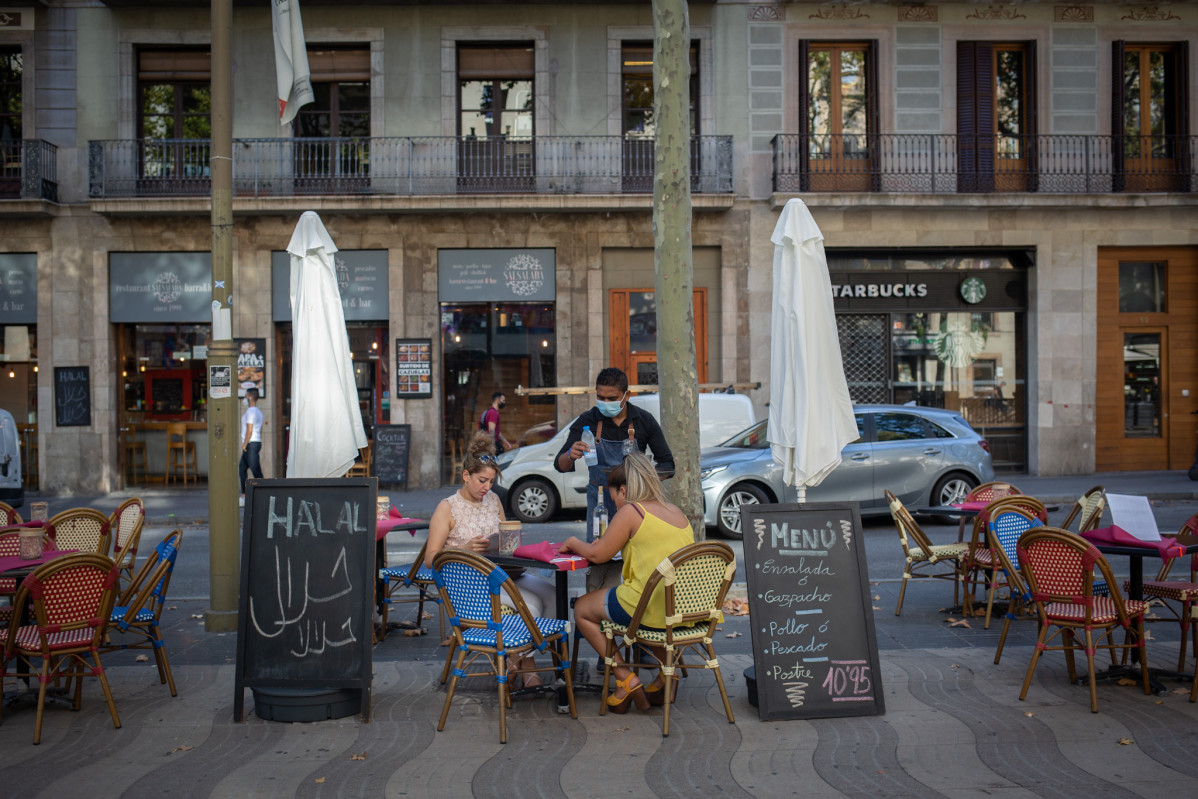 Dues dons mengen na terrassa d'un bar a Barcelona, Catalunya (Espanya) a 14 d'outubro de 2020.