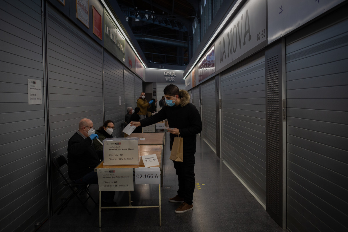 Un home vota nunha mesa electoral do Mercado St. Antoni en Barcelona, Cataluña (España), ao 14 de febreiro de 2021.
