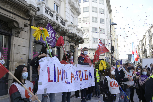 Varias persoas con fregonas e unha pancarta nunha protesta convocada por CIG, CCOO e UXT para visibilizar a folga do sector da limpeza na provincia da Coruña