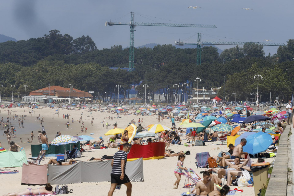 Varias personas se bañan y toman el sol en la playa de Samil, en Vigo, Pontevedra, Galicia (España). Galicia vive un fin de semana con temperaturas de verano y las máximas superarán este domingo l