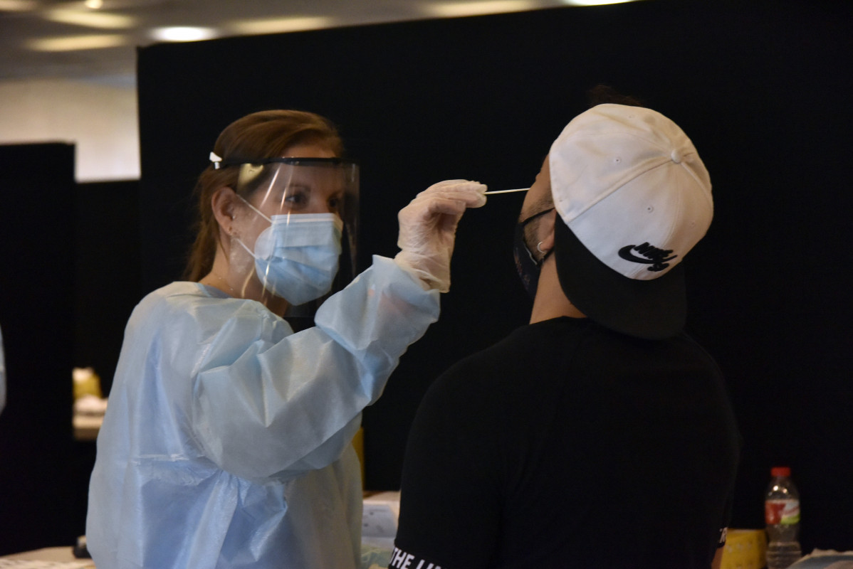 Unha traballadora sanitaria realiza un test de antígenos a un mozo