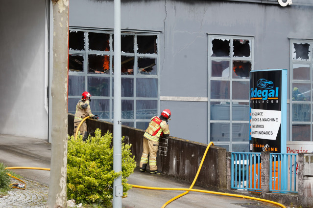 Bomberos en las inmediaciones de una nave de desguace donde se ha producido un incendio, en el polígono de O Ceao, a 26 de marzo de 2024, en O Ceao, Lugo, Galicia (España).