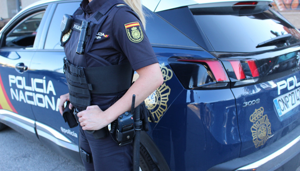 Un agente y un vehículo de la Policía Nacional