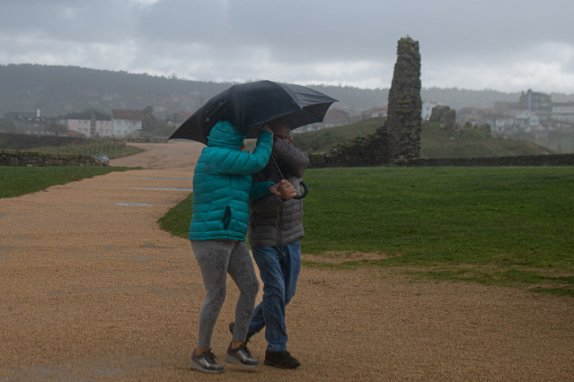Archivo - Dos personas se protegen de la lluvia con un paraguas, en la playa de A Lanzada, a 5 de noviembre de 2023, en O Grove, Pontevedra, Galicia (España).