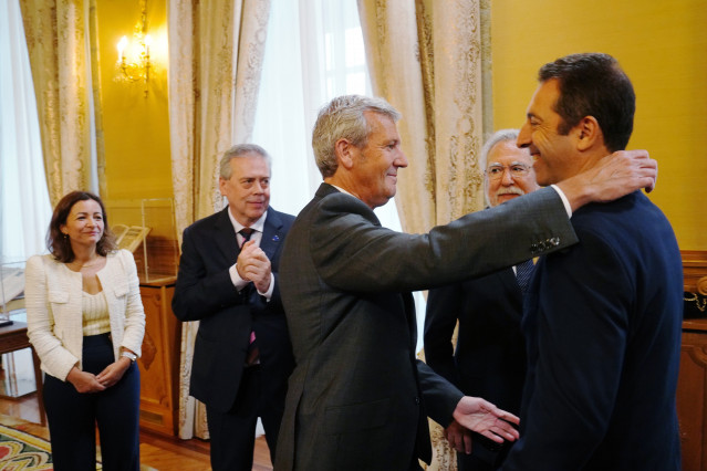 El presidente de la Xunta, Alfonso Rueda, abraza al hasta ahora conselleiro do Mar, Alfonso Villares, en el acto de posesión de la nueva conselleira