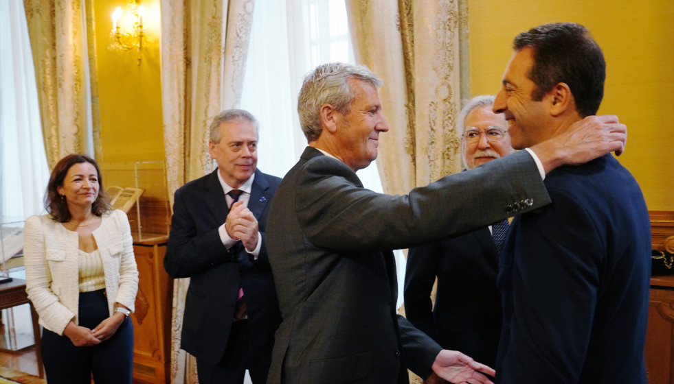El presidente de la Xunta, Alfonso Rueda, abraza al hasta ahora conselleiro do Mar, Alfonso Villares, en el acto de posesión de la nueva conselleira