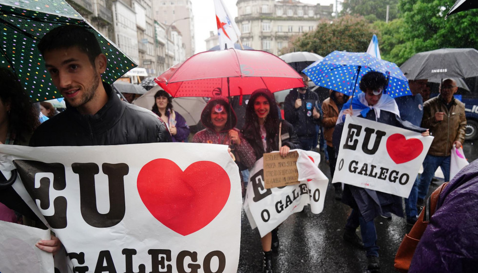 Varias personas con paraguas y carteles en los que se lee: 'Eu O Galego (hablo gallego)', participan en una manifestación, bajo el lema: ‘Queremos Galego’, a 17 de mayo de 2022, en Santiago de Co