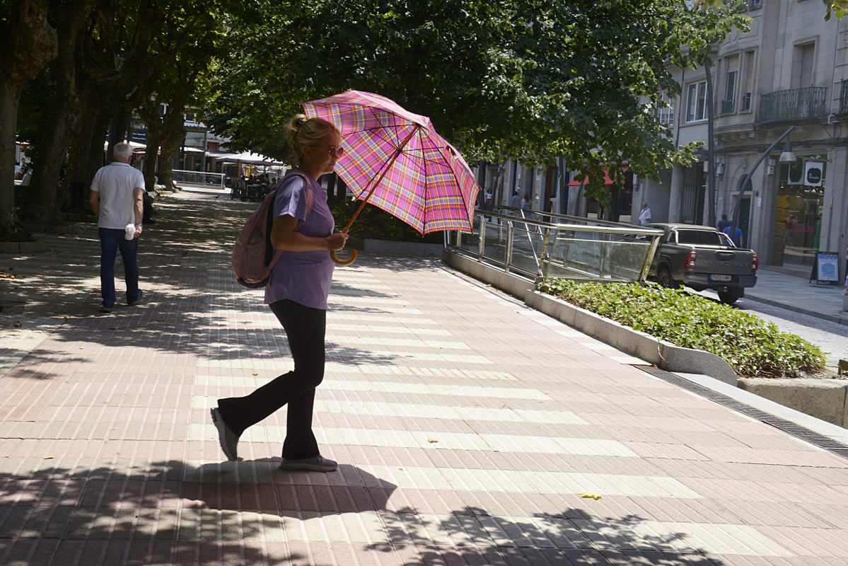Archivo - Una mujer camina por una vía en plena ola de calor, a 12 de julio de 2022, en Orense, Galicia (España). Los termómetros de la práctica totalidad del territorio gallego alcanzarán valore
