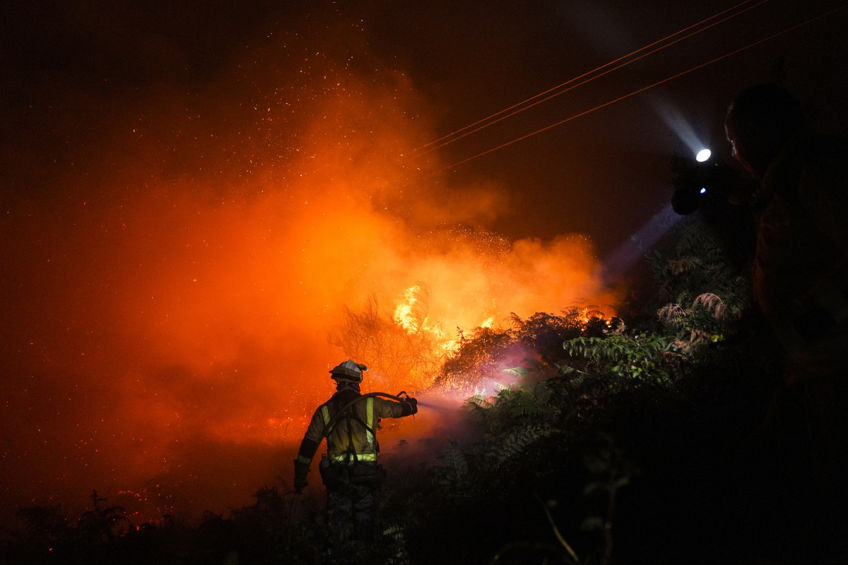 Un bombero trata de extinguir el fuego.