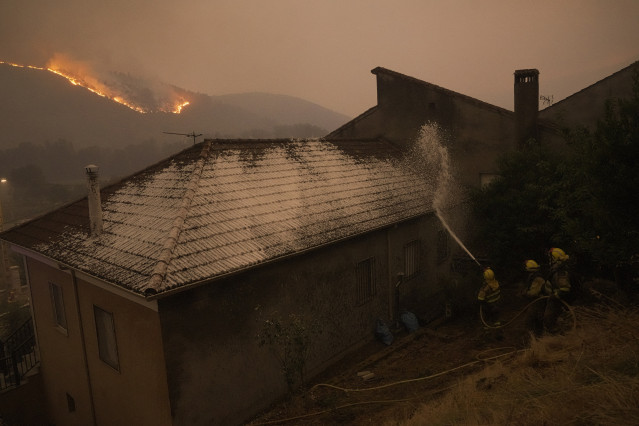 Varios bomberos forestales tratan de extinguir un fuego, a 17 de agosto de 2025, en Retorta, Laza, Ourense, Galicia (España).