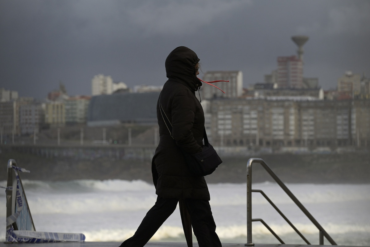 Archivo - Una mujer se cubre con la capucha durante el frente meteorológico, a 23 de febrero de 2024, en A Coruña, Galicia (España). La Agencia Estatal de Meteorología (Aemet) decretó un aviso na