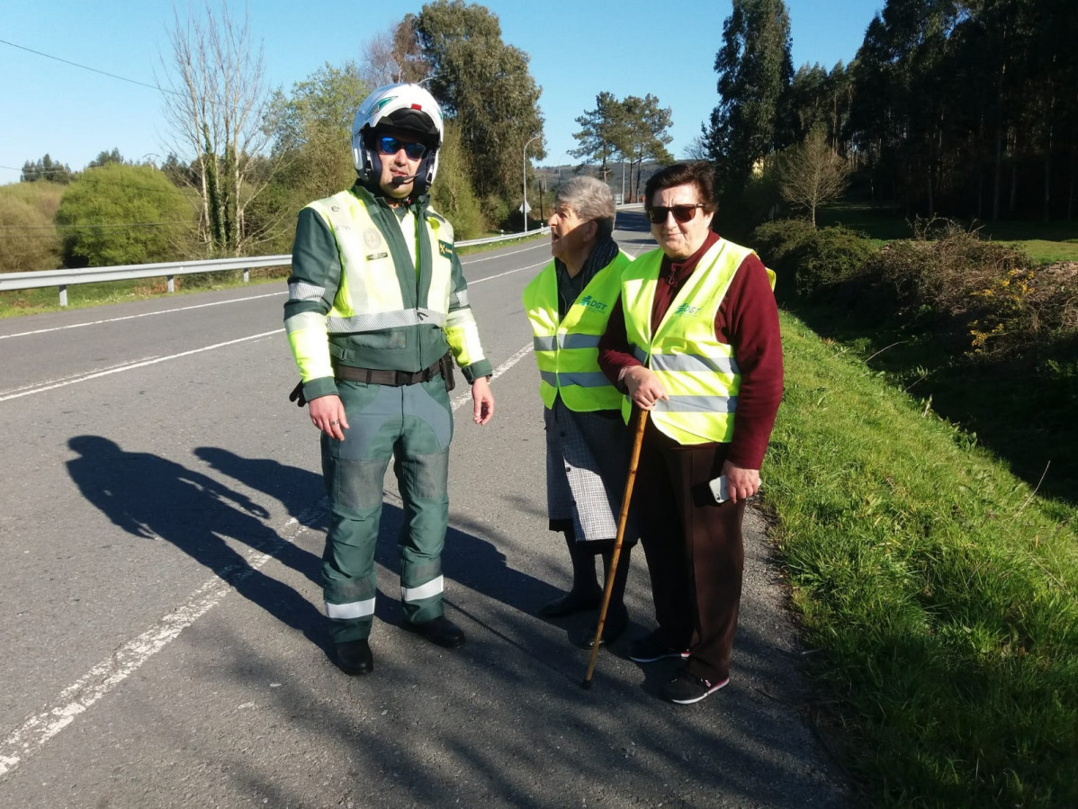 Archivo - Guardia Civil de Tráfico entrega a peatones chalecos reflectantes