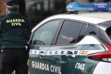 Un agente de la Guardia Civil junto a un vehículo oficial. Imagen de archivo.