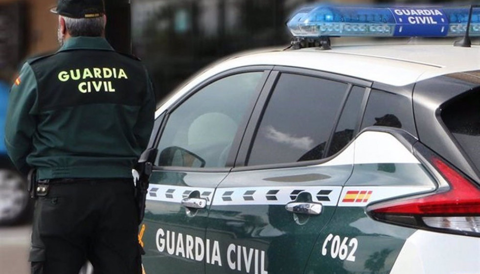 Un agente de la Guardia Civil junto a un vehículo oficial. Imagen de archivo.