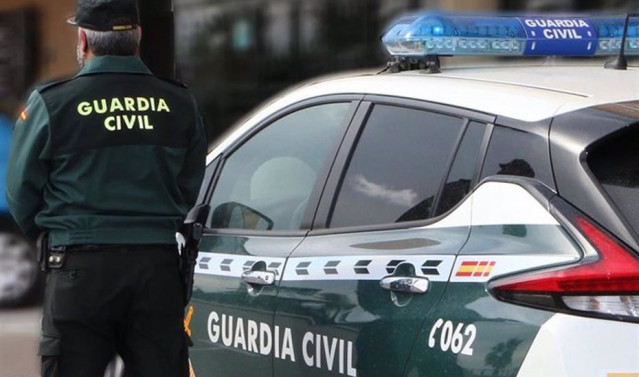Un agente de la Guardia Civil junto a un vehículo oficial. Imagen de archivo.
