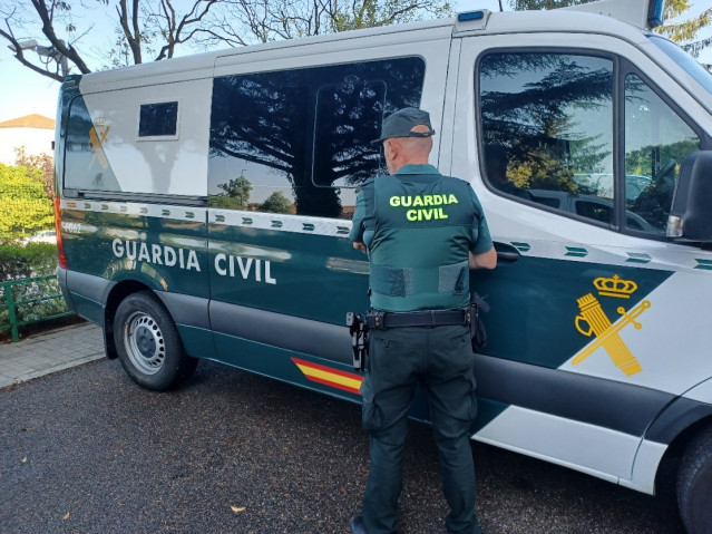 Archivo - Imagen de una furgoneta y un agente de la Guardia Civil.