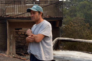 Samuel, veciño da Caridade (Cualedro) diante da súa casa destruída polo lume nunha foto de Rosa Veiga