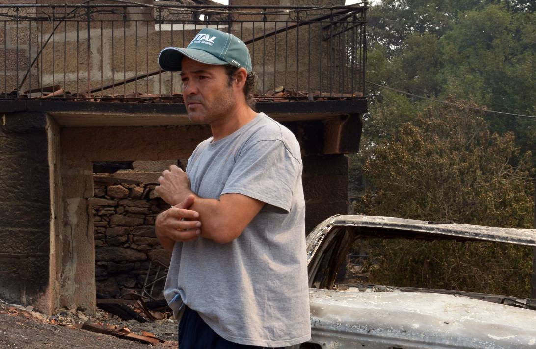 Samuel, veciño da Caridade (Cualedro) diante da súa casa destruída polo lume nunha foto de Rosa Veiga