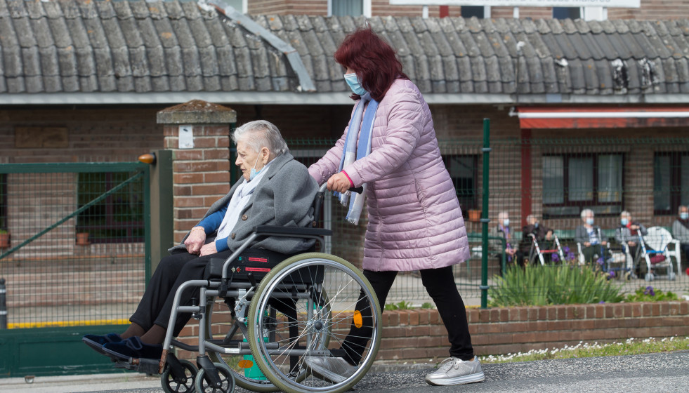 Archivo - Una mujer pasea a una anciana en silla de ruedas, en las inmediaciones de la residencia geriátrica de As Gándaras para visitar a un familiar, a 17 de abril de 2021, en Lugo, Galicia (Espa