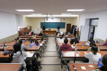 Archivo - Un grupo de personas esperan a realizar las pruebas de Formación Sanitaria Especializada convocada por el Ministerio de Sanidad, en la Facultad de Medicina de la Universidad de Santiago de