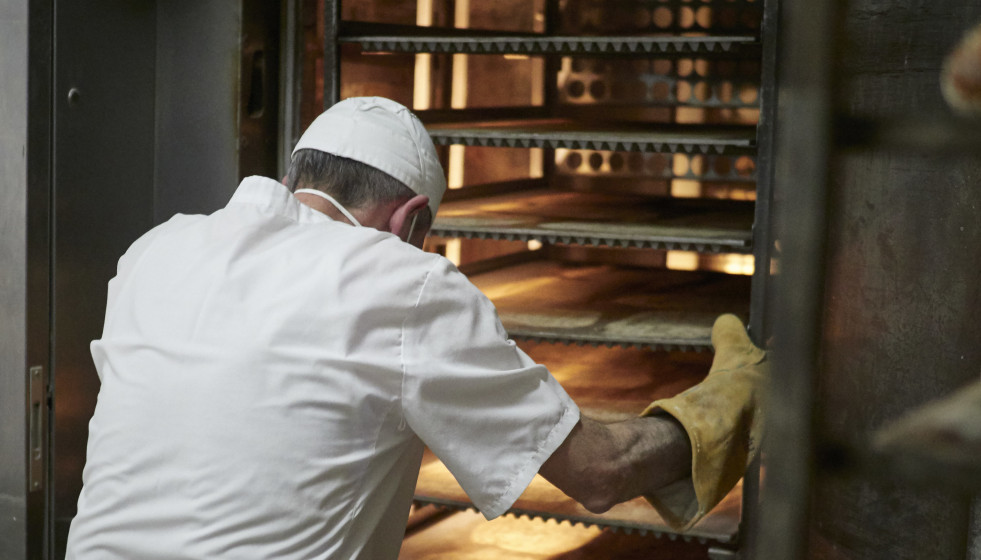 Archivo - Un trabajador protegido con mascarilla y guantes maneja bandejas para cocer el pan en el obrador panadería 'Panadero de Eugui' durante en el día 32 del estado de alarma, uno de los estable