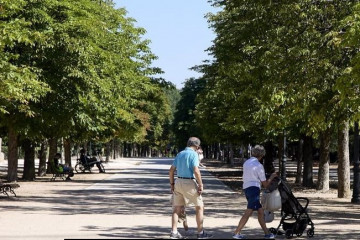 Archivo - Abuelos  paseando a su nieto.