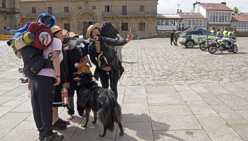 Archivo - Varios peregrinos se toman una foto, a su llegada a la Catedral de Santiago, durante la presentación del dispositivo de seguridad establecido para el Año Santo Xacobeo en la plaza del Obra