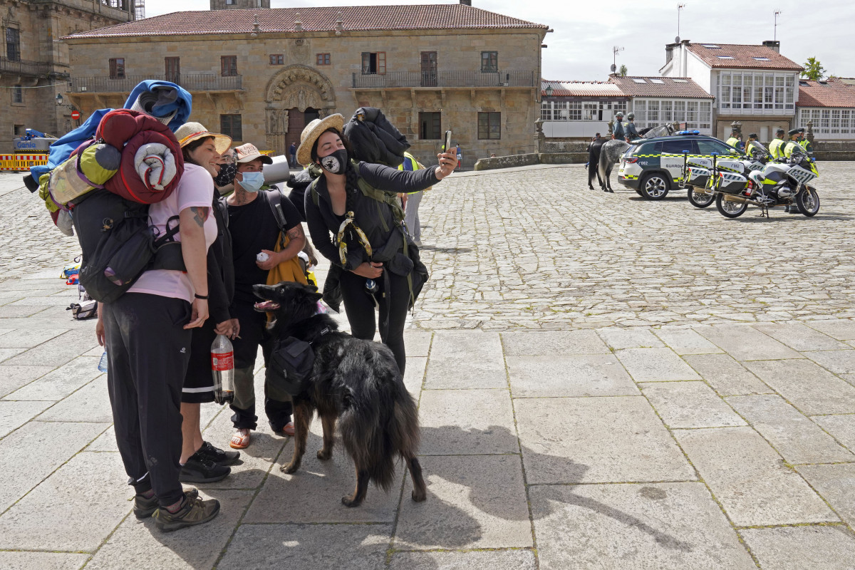 Archivo - Varios peregrinos se toman una foto, a su llegada a la Catedral de Santiago, durante la presentación del dispositivo de seguridad establecido para el Año Santo Xacobeo en la plaza del Obra