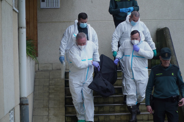 Operarios que participan en la retirada de basura y de un cadáver en una vivienda de Oleiros (A Coruña)