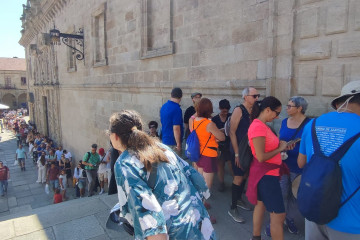 Centenares de peregrinos y turistas en la larga cola que atraviesa la escalinata de la Praza de la Quintana ayer para entrar a la Catedral