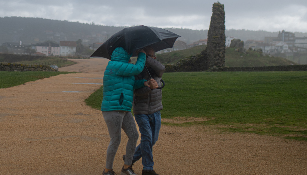 Archivo - Dos personas se protegen de la lluvia con un paraguas, en la playa de A Lanzada, a 5 de noviembre de 2023, en O Grove, Pontevedra, Galiciia.
