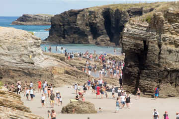 Archivo - Turistas pasean por la playa de Las Catedrales.