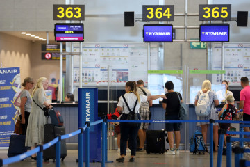 Archivo - Cientos de turistas hacen colas en los puestos de embarque de Ryanair, en el Aeropuerto Costa del Sol.