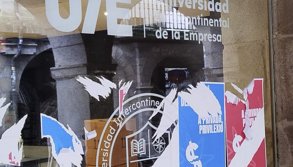 Restos de carteles en la vidriera de la sede de la UIE en Santiago de Compostela