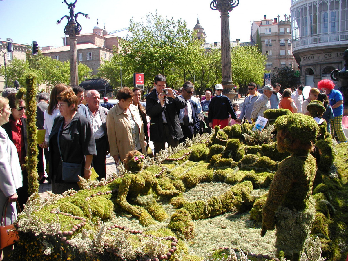Archivo - Os maios, grandes figuras vegetales, colocados en las calles de Ourense atraen la mirada de los turistas.