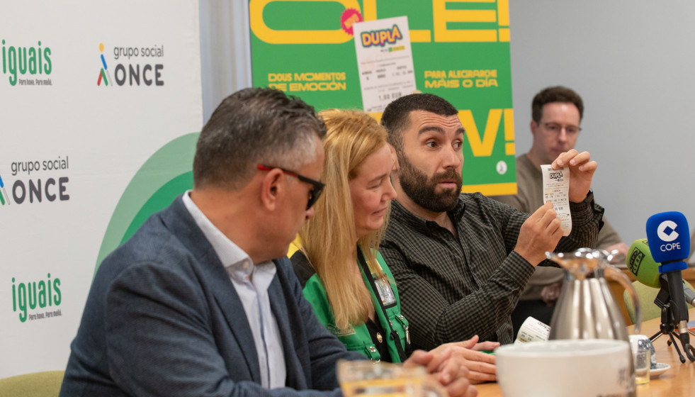 Adrián González muestra un boleto de Dupla, junto a Manuel Martínez Pan y la vendedora de la ONCE Izabel  Cristina Dos Santos