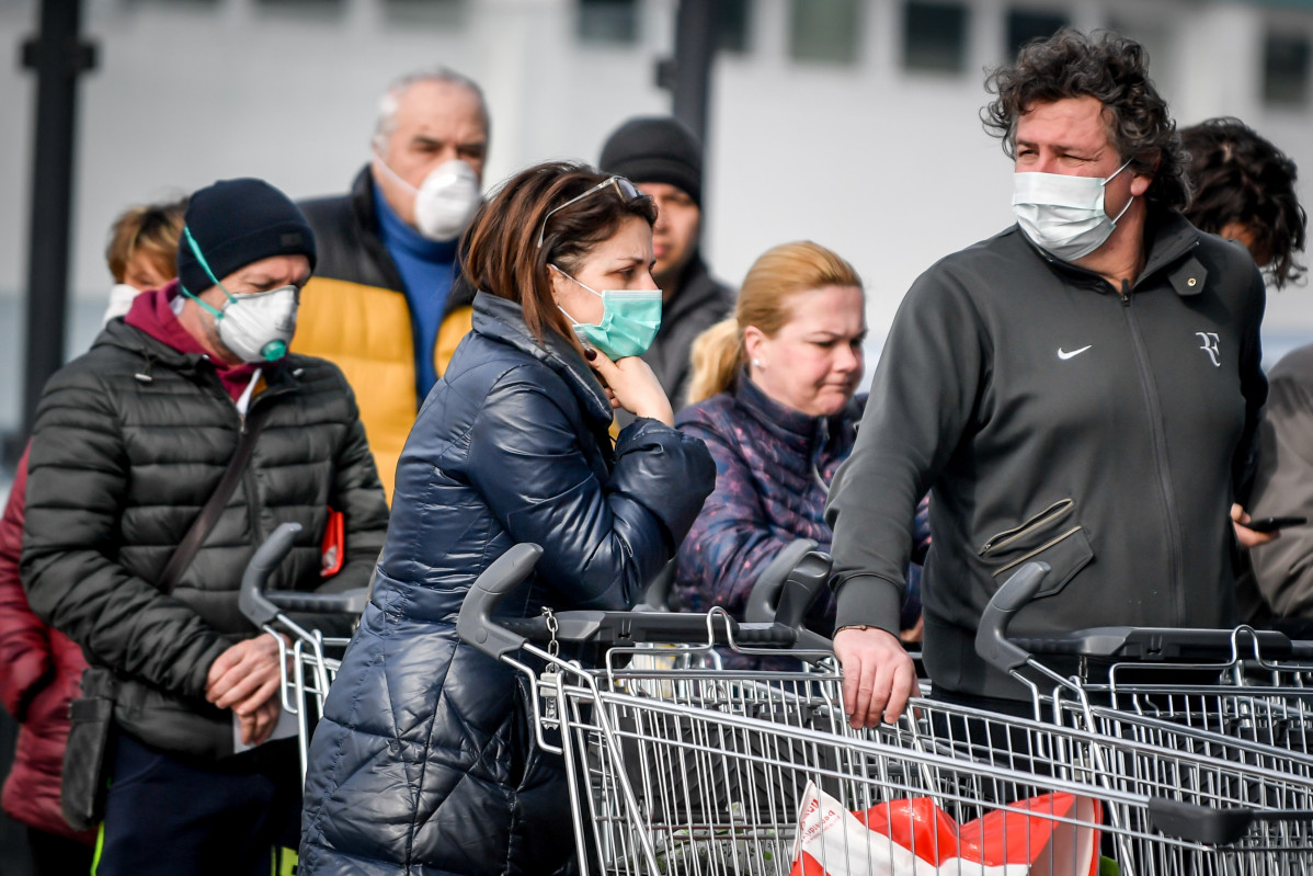 Persoas con mu00e1scaras ciru00farxicas fan cola diante dun supermercado en zona de Italia onde se detectou a propagaciu00f3n do coronavirus Foto de Claudio  Furlan