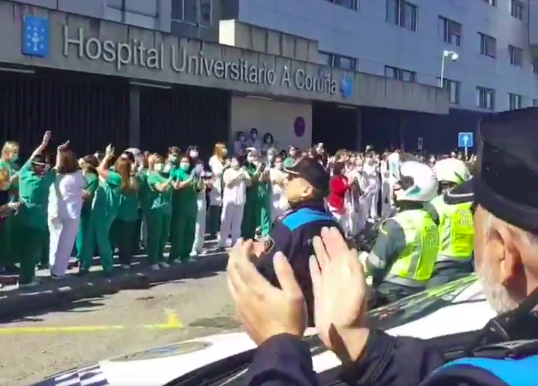 Policu00edas e sanitarios intercambian aplausos en plena crise do coronavirus fronte Hospital Universitario A Coruu00f1a