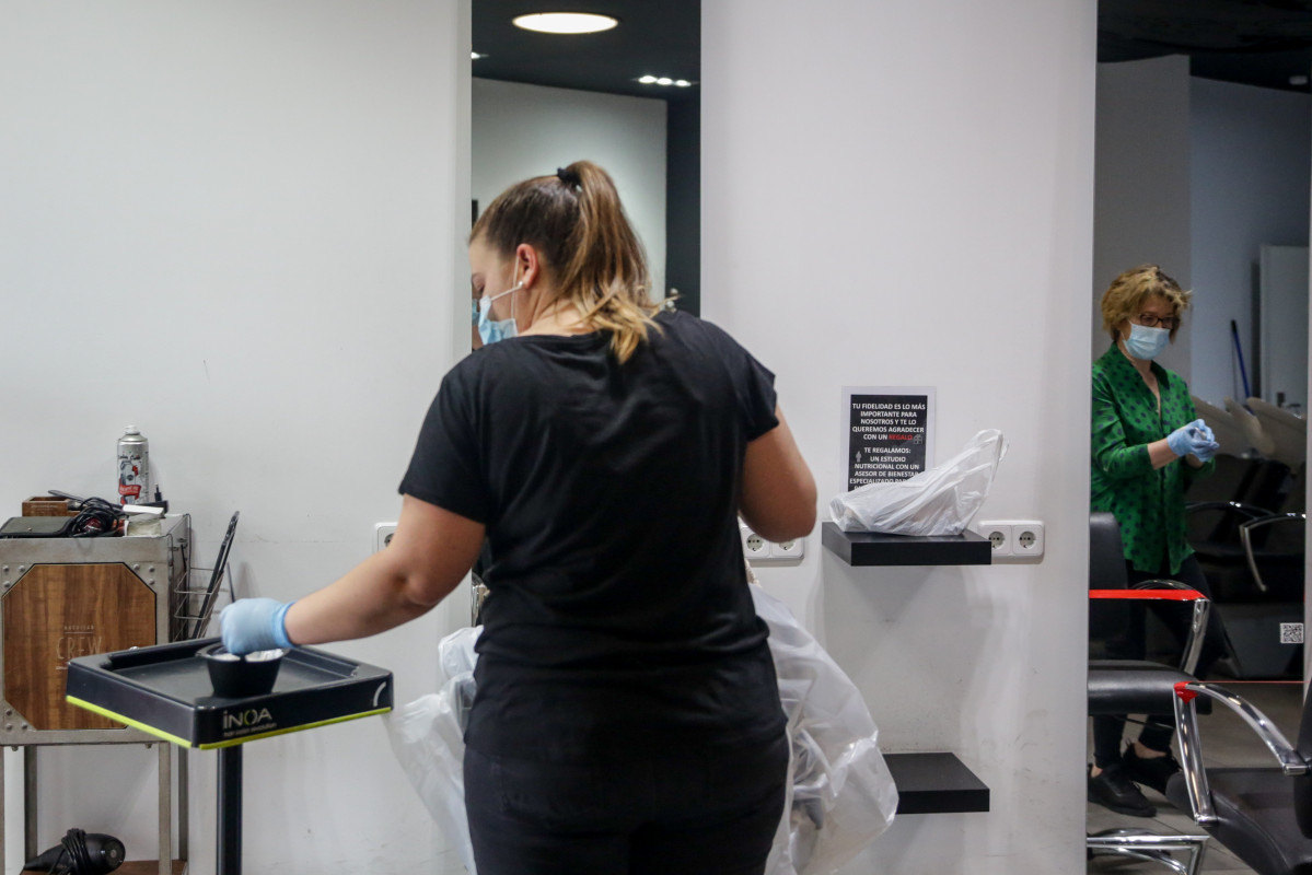 Unha empregada da barbería Krackhair (C/Embaixadores, 3, Madrid) aberta durante o día 51 do estado de alarma.