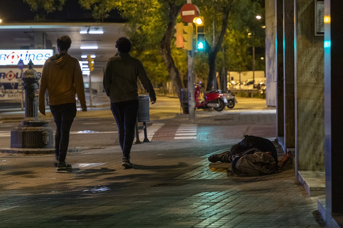 Unha persoa sen fogar durmindo na rúa, preto da Estación de Sants de Barcelona, durante a noite do reconto de persoas sen teito organizada pola Fundació Arrels o pasado 14 de maio do 2020, durante a epidemia do coronavirus.