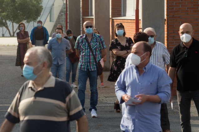 Varias persoas fan cola para votar nas eleccións autonómicas de Galicia na poboación de Burela