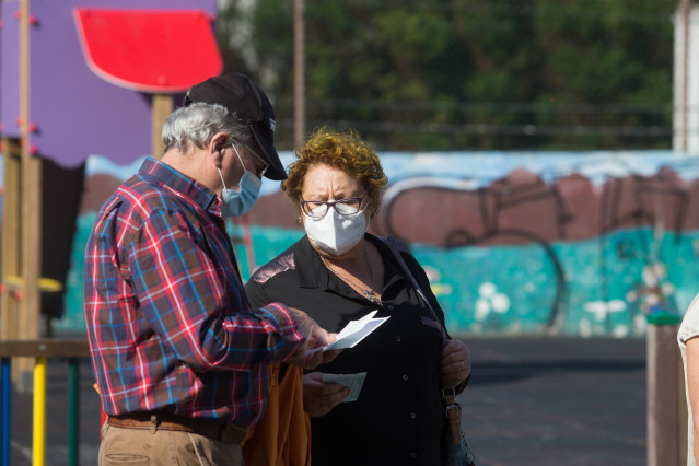 Dúas persoas con máscaras ante o Pavillón Vos Castros, en Burela (Lugo).