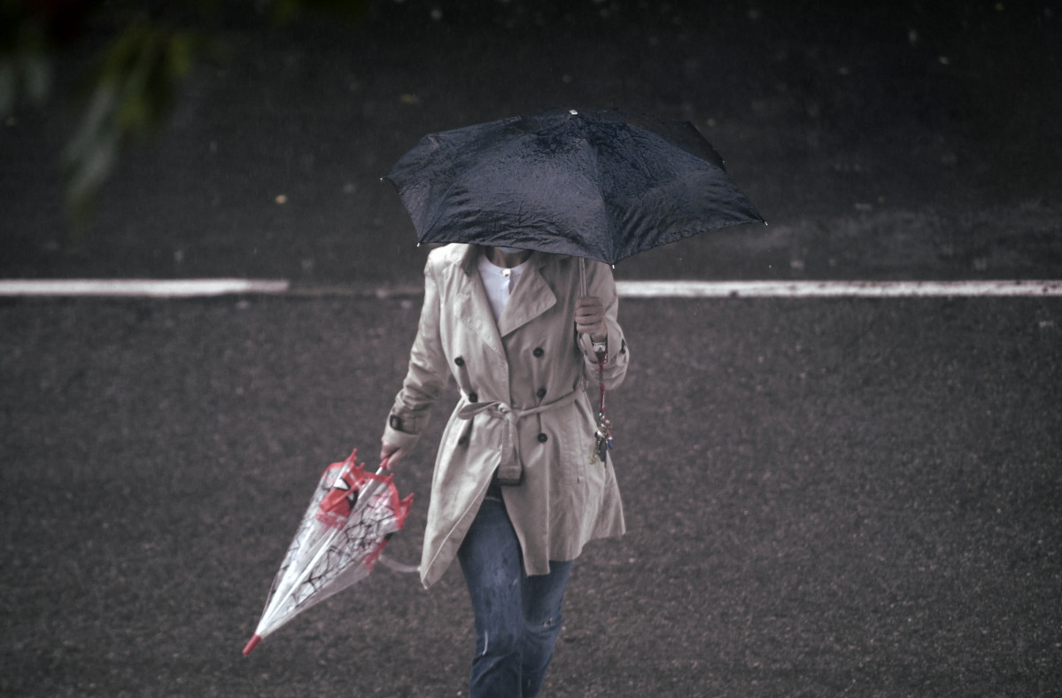 Unha persoa camiña baixo a choiva protexida cun paraugas, en Madrid (España) ao 24 de setembro de 2020. A cidade rexistrou un chuvasco intenso este xoves entre as 08.30 e as 10.00 horas e
