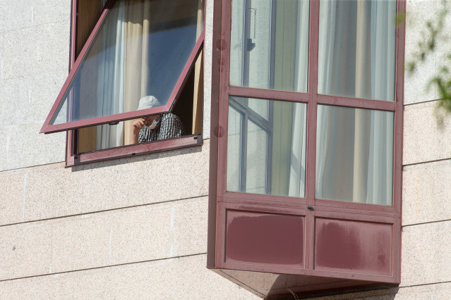 Unha persoa asómase pola xanela da residencia de maiores DomusVi de Outeiro de Rei en Lugo, Galicia (España), ao 8 de setembro de 2020. A Xunta interveu o xeriátrico tras detectar 99 positivos máis en covid-19, 94 deles en usuarios e cin