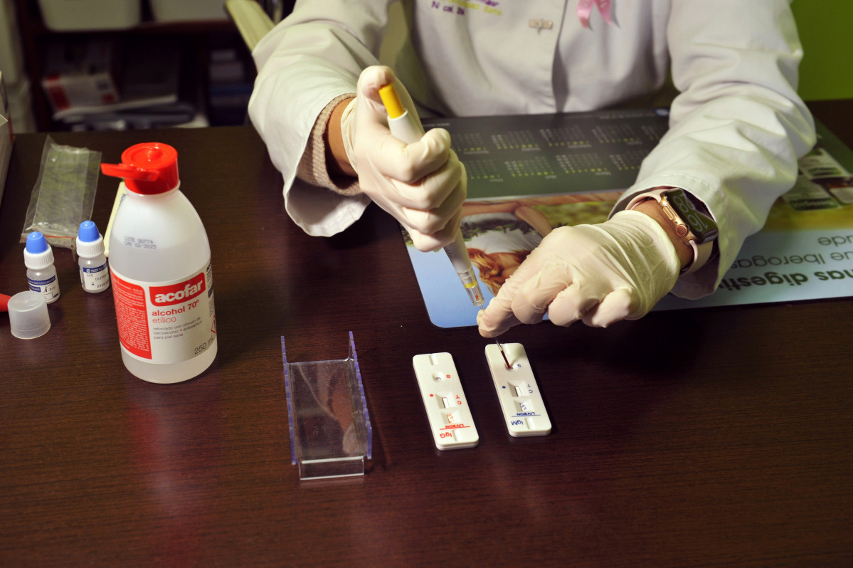 Unha farmacéutica da Farmacia Portal Martínez Soto introduce nunha placa a mostra de sangue que tomou para realizar un test de cribado do coronavirus en Barbadás, Ourense, Galicia (Españ