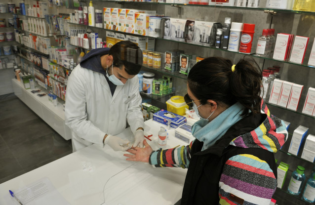Un farmacéutico realiza unha proba serológica de Covid-19 na Farmacia Mónica Muradas, no Carballiño, Ourense, Galicia (España), ao 22 de outubro de 2020. O comité clínico da Consellería de Sanidade decidiu manter o nivel 3 nos ayuntamien