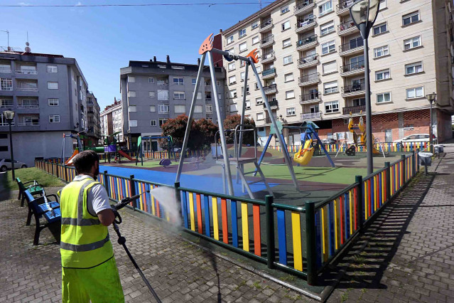 Un traballador desinfecta un parque infantil de Ponteareas