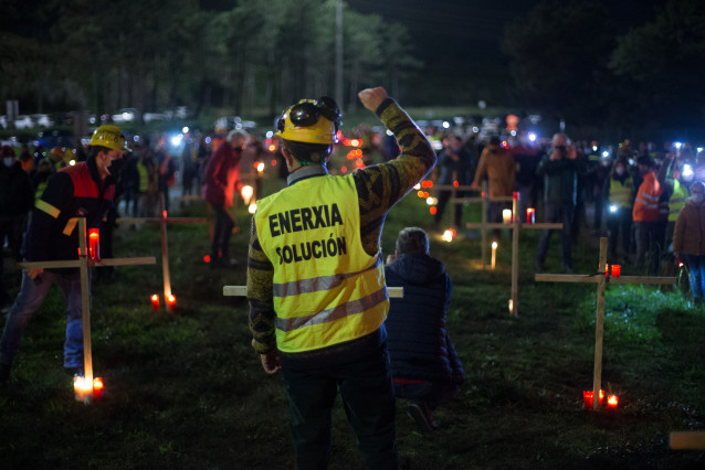 Un traballador levanta o brazo como signo de protesta durante un velorio nocturno simbólico convocado pola fábrica de Alcoa, en en  San Cibrao, A Mariña, Lugo, Galicia (España), ao 28 de novembro de 2020. A concentración prodúcese como signo de prot
