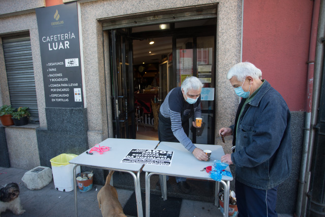 Un establecemento serve cafés para levar o mesmo día da entrada en vigor de novas restricións impostas pola crise do Covid-19 no municipio de Vilalba, Lugo.